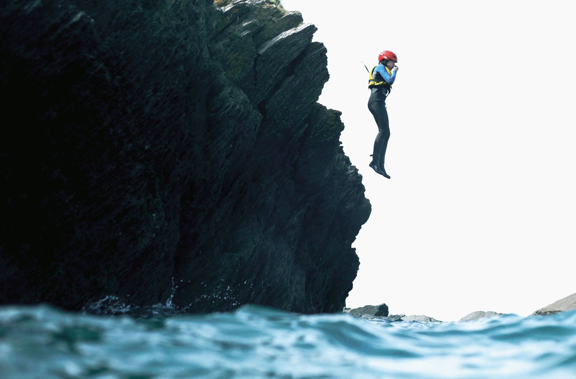 A person jumping into the sea during coasteering